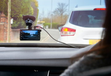 A dash cam installed on the windshield records the traffic in front of the car.