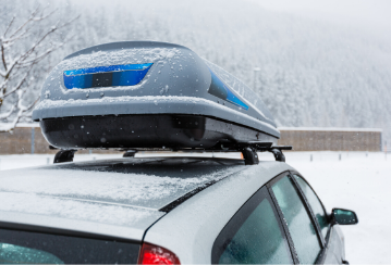 Car with a roof rack driving in winter.